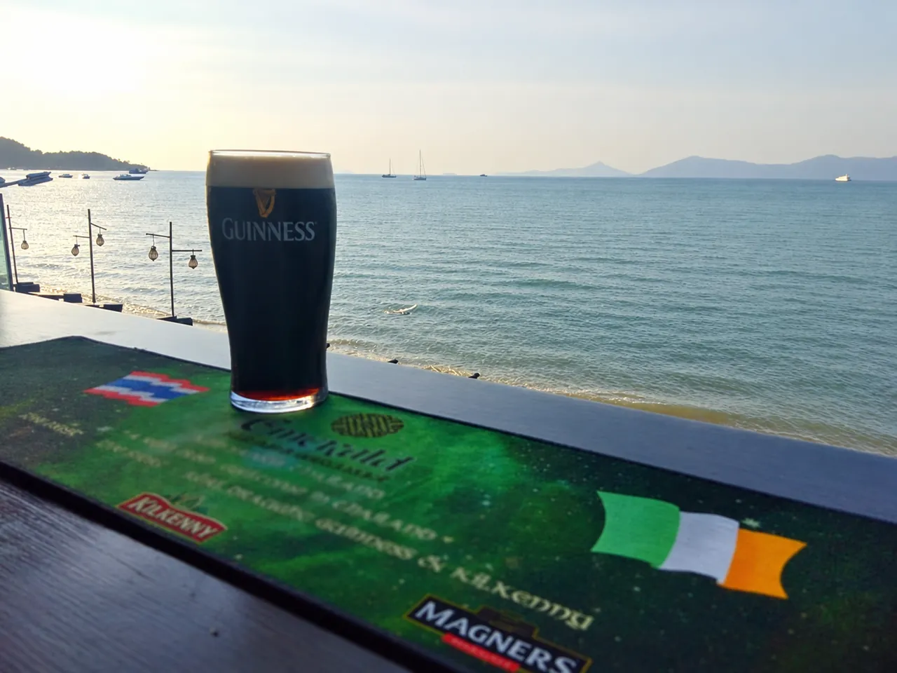 A pint of Guinness on the sea-facing bar ledge, with the bay behind